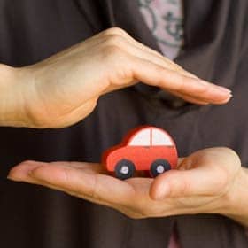 person holding tiny car
